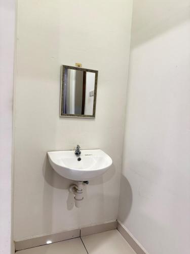 a white bathroom with a sink and a mirror at Spacious 1BR Apartment Bukit Jalil in Serdang