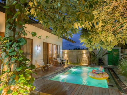 a swimming pool in a backyard with a house at Karuna Villa Prambanan in Yogyakarta