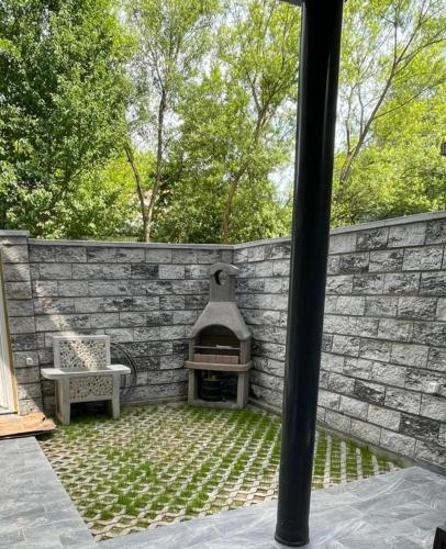 a patio with a brick wall and an outdoor oven at Crater H in Kukrike