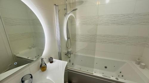une salle de bain avec une douche, un lavabo et une baignoire dans l'établissement un cocon a deux pas du métro et avec parking inclus, à Paris
