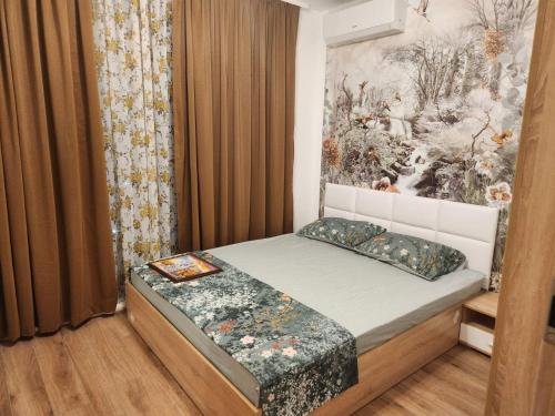 a bedroom with a bed with a painting on the wall at Lili Azur beach appaartment in Varna City