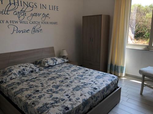 a bedroom with a bed and a quote on the wall at B&B Isola Mia in La Maddalena