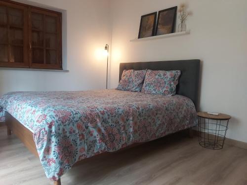 a bedroom with a bed with a floral bedspread at Casa Vale Nicolau in Arganil