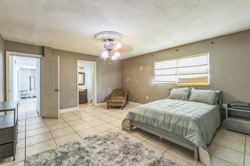 a bedroom with a bed and a couch and a window at Amazing 'Hot Tub' Home Minutes To Hospitals & Beaches in Palmetto