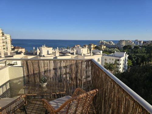a balcony with two chairs and a view of the city at Intercomercio Feja Jupiter in Benalmádena