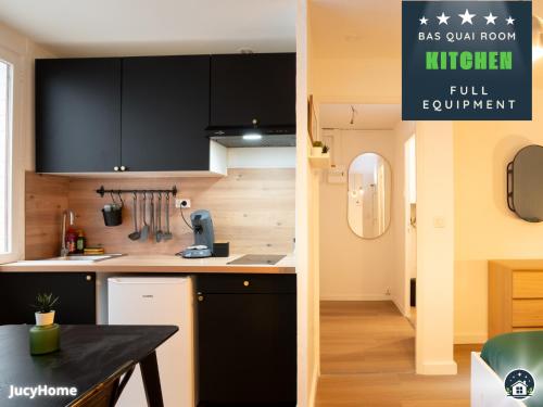 a kitchen with black and white cabinets and a table at Le 44 Saint-Louis in Boulogne-sur-Mer