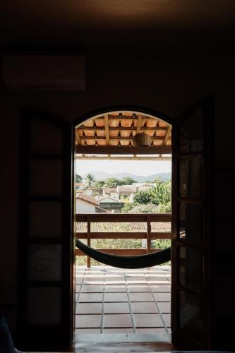 an open door to a porch with a hammock outside at Pousada Recanto da Ladeira in Paraty