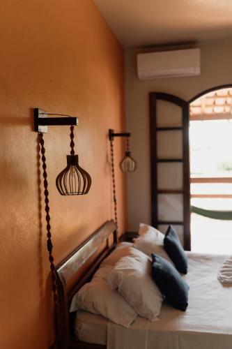 a bedroom with a bed with pillows on it at Pousada Recanto da Ladeira in Paraty