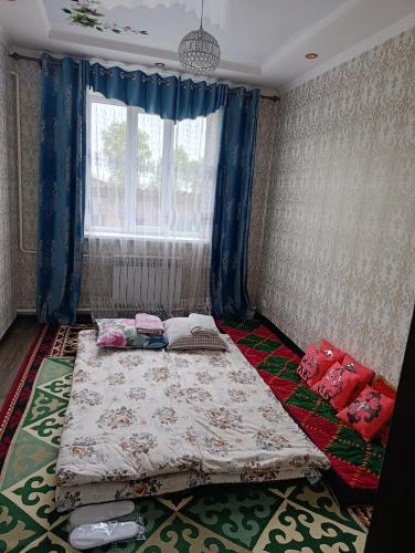 a bedroom with a bed and a window at Jusup Guest House, Hostel in Dzhangyaryk