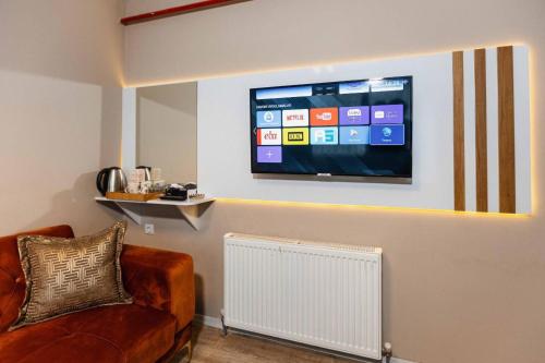 a living room with a couch and a tv on the wall at Lina Suit Hotel in Istanbul