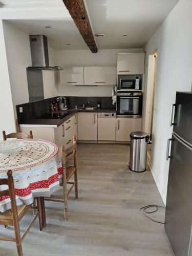 - une cuisine avec une table, une table et des chaises dans l'établissement Le Minimosa T2 au pied du métro, à Toulouse