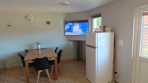 kuchnia ze stołem, lodówką i telewizorem w obiekcie Domek Olivia Wilkasy, Mazury w mieście Wilkasy