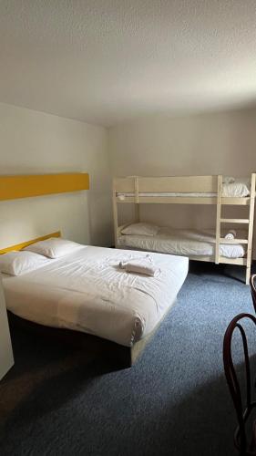 a bedroom with a bed and two bunk beds at Quick Palace Anglet in Anglet