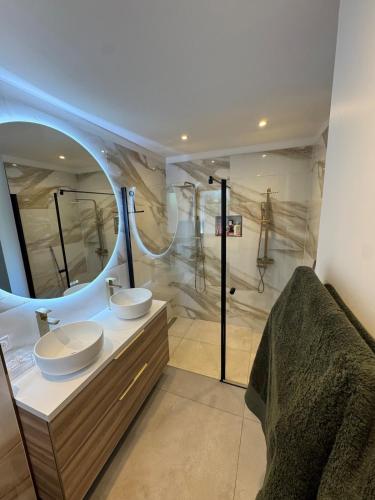 une salle de bain avec deux lavabos et un grand miroir dans l'établissement Villa neuve plage a pied, à Saint-Cyr-sur-Mer