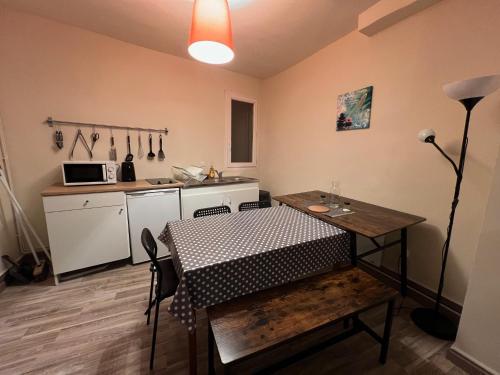 une chambre avec une table et une cuisine avec un comptoir dans l'établissement Le bonheur partagé au Puy en Velay, au Puy-en-Velay