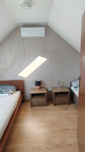 a attic room with two beds and two tables at Domek Olivia Wilkasy, Mazury in Wilkasy