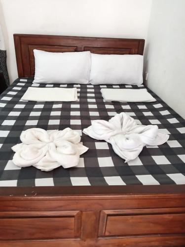 a bed with two white towels on it at TrincoBeCoolGuest & Hostel in Trincomalee