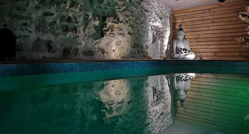 - une piscine avec une statue à côté dans l'établissement GITE DE MONTAGNE 