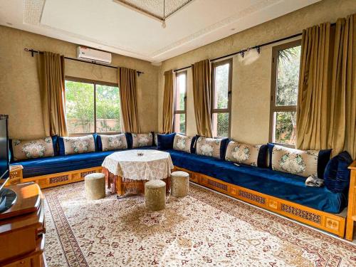 a living room with a blue couch and a table at Piscine et montagnes, villa 40 min Marrakech in Ourika