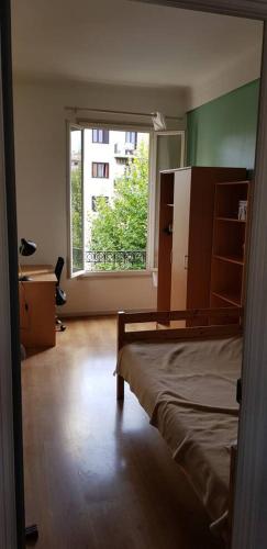 une chambre avec un lit et une grande fenêtre dans l'établissement Appartement lumineux, à Nice