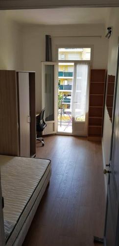 une chambre vide avec un lit et un bureau. dans l'établissement Appartement lumineux, à Nice