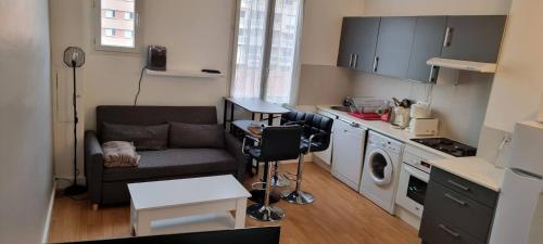 un salon avec un canapé et une cuisine dans l'établissement Appartement lumineux, à Nice