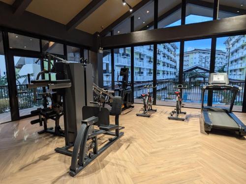 a gym with cardio equipment in a building with windows at Luxury Budget one Bedroom with living room and Kitchen Rest and fly at Amani Grand Resort in Pusok