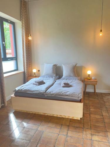 a bed in a room with two lamps on two tables at Helle Loft mit eingenem Garten in Templin
