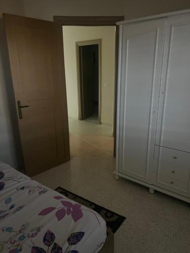 a bedroom with a bed and a closet and a door at Appartement nasria in Sfax