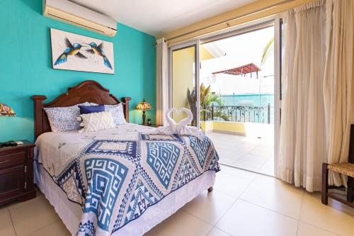 a bedroom with a bed with blue walls and a balcony at Cheerful 4 Bedroom house with Swimming Pool in Mezcales