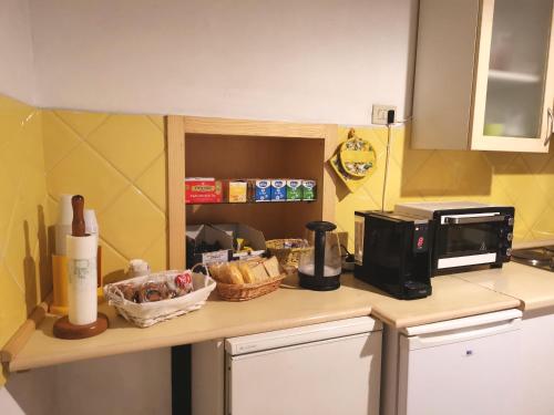 a kitchen counter with a microwave and some food on it at Camere la torre in Volterra