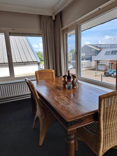 a dining room table with chairs and a large window at Chang in Egmond aan den Hoef