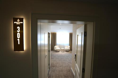 a hallway with a door leading to a room with chairs at Avdissons Hotel in Prizren