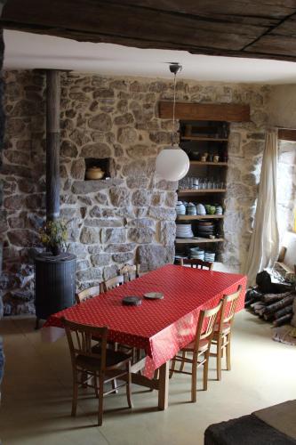 une salle à manger avec une table et des chaises rouges dans l'établissement Maison Familiale et Chaleureuse, à Laboule