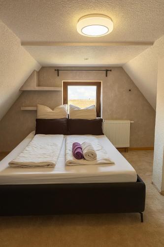 a large bed with two towels on it in a room at Small House park free at street in Stuttgart