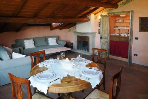 une salle à manger avec une table et un canapé dans l'établissement La Rocca -- Monticello Apartments, à Medesano