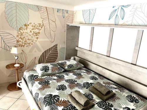 une chambre avec un lit avec des oreillers dessus dans l'établissement Cozy duplex near the beach with with Aircon, à Nice