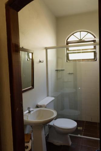 a bathroom with a toilet and a sink and a shower at Pousada Recanto da Ladeira in Paraty