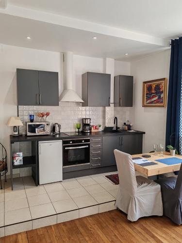 une cuisine avec des appareils en acier inoxydable et une table dans l'établissement Le Jean Jaurès, à Troyes