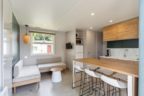a kitchen with a counter and a bar with stools at Maison de Vacances - Parc de Vacances Papillon Bouillon in Bouillon