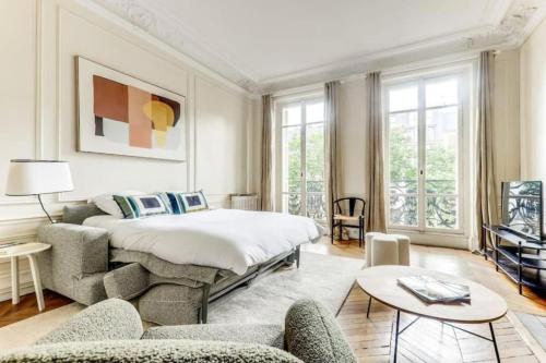 une chambre avec un lit, un canapé et des chaises dans l'établissement La Fleur du Bosquet - Sumptuous- Eiffel Tower view, à Paris