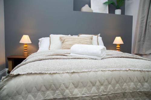 a bedroom with a large bed with two lamps at Sleeps 14 The Old Trafford Family Zen by Genesis Living in Manchester