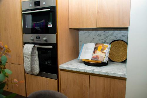 a kitchen with a counter top with a microwave at Sleeps 14 The Old Trafford Family Zen by Genesis Living in Manchester