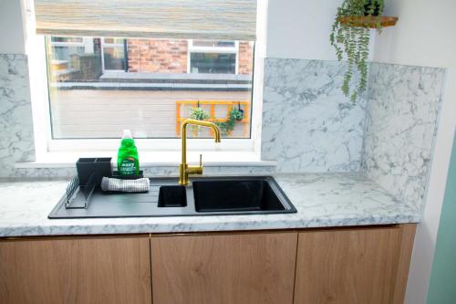 a kitchen counter with a sink and a window at Sleeps 14 The Old Trafford Family Zen by Genesis Living in Manchester