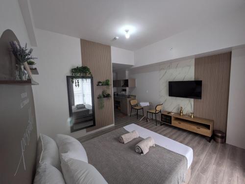 a hotel room with a bed and a television at Cebu Airport budget Luxury living Rest& Fly at Amani Grand Resort in Pusok