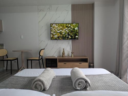 a bedroom with a bed with a television on the wall at Cebu Airport budget Luxury living Rest& Fly at Amani Grand Resort in Pusok