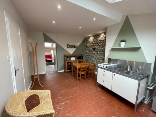 eine Küche mit Theke und Tisch und eine Küche in der Unterkunft Nid Douillet Sous Les Toits - Calme et Cosy in Saint-Étienne
