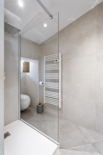 La salle de bains est pourvue d'une douche en verre et de toilettes. dans l'établissement Nice Renting - 6B FRANCE - Massena beach design AC quiet center wifi, à Nice