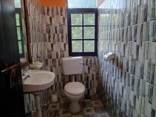 a bathroom with a toilet and a sink and a window at Vera Cruiz one bedroom CBD in Malindi