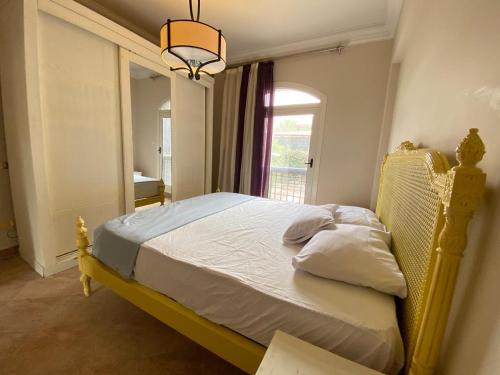 a bedroom with a bed and a chandelier at فيلا راقية تاني صف بحيرة in El Alamein